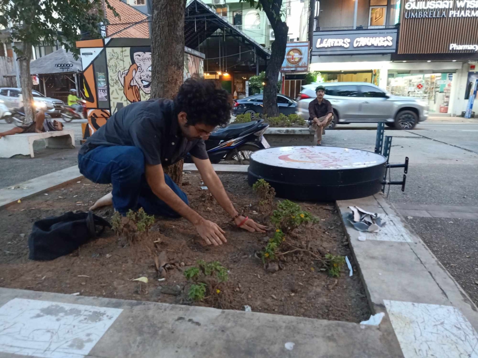the artist smooths out the dirt, preparing it for construction