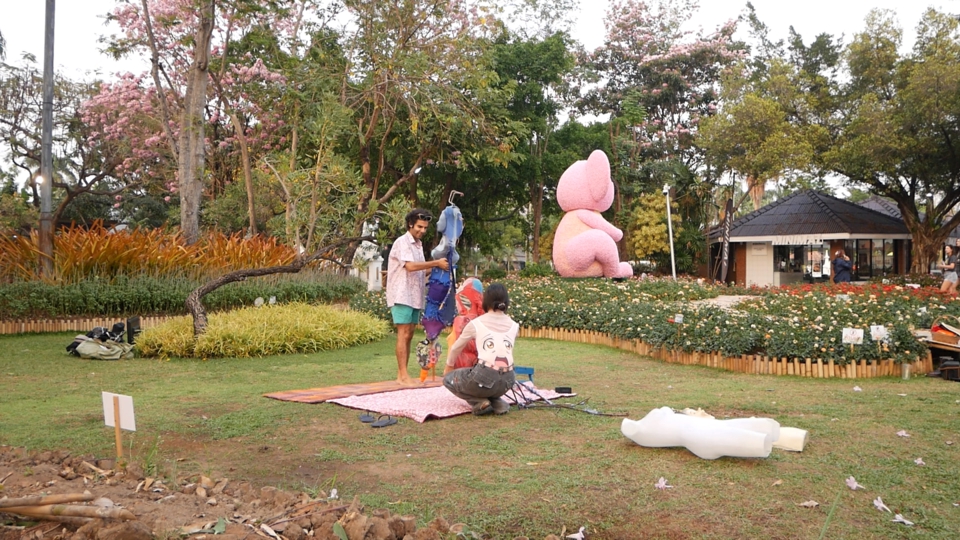 stephan holds the blue, two-torsoed mannequin while juno crouches with the red spider mannequin